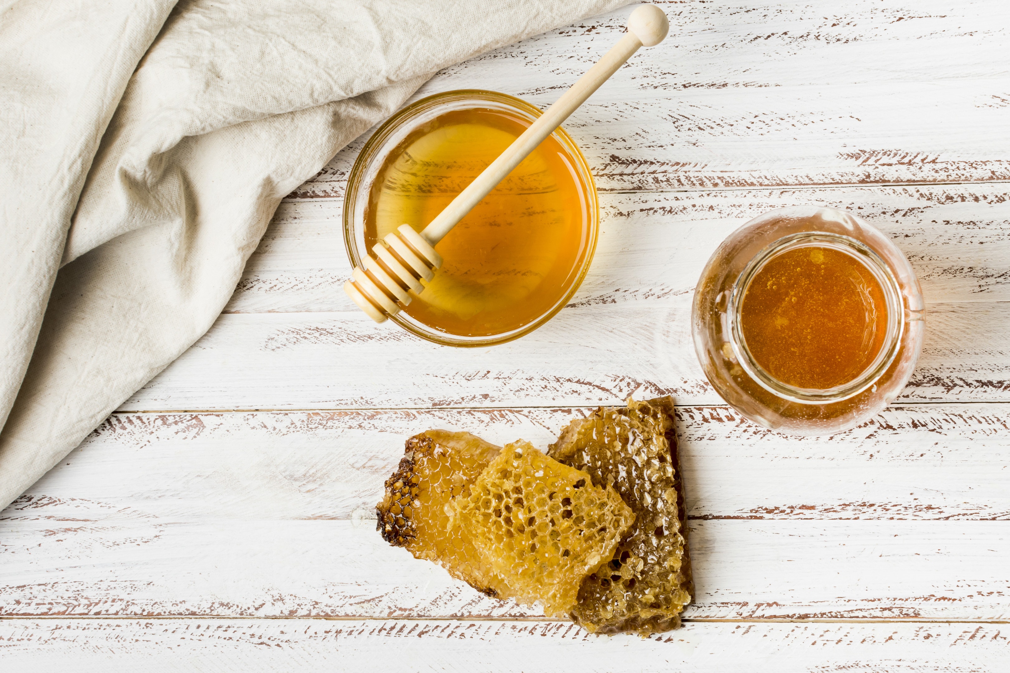 Honey jars with honeycomb on wooden table
