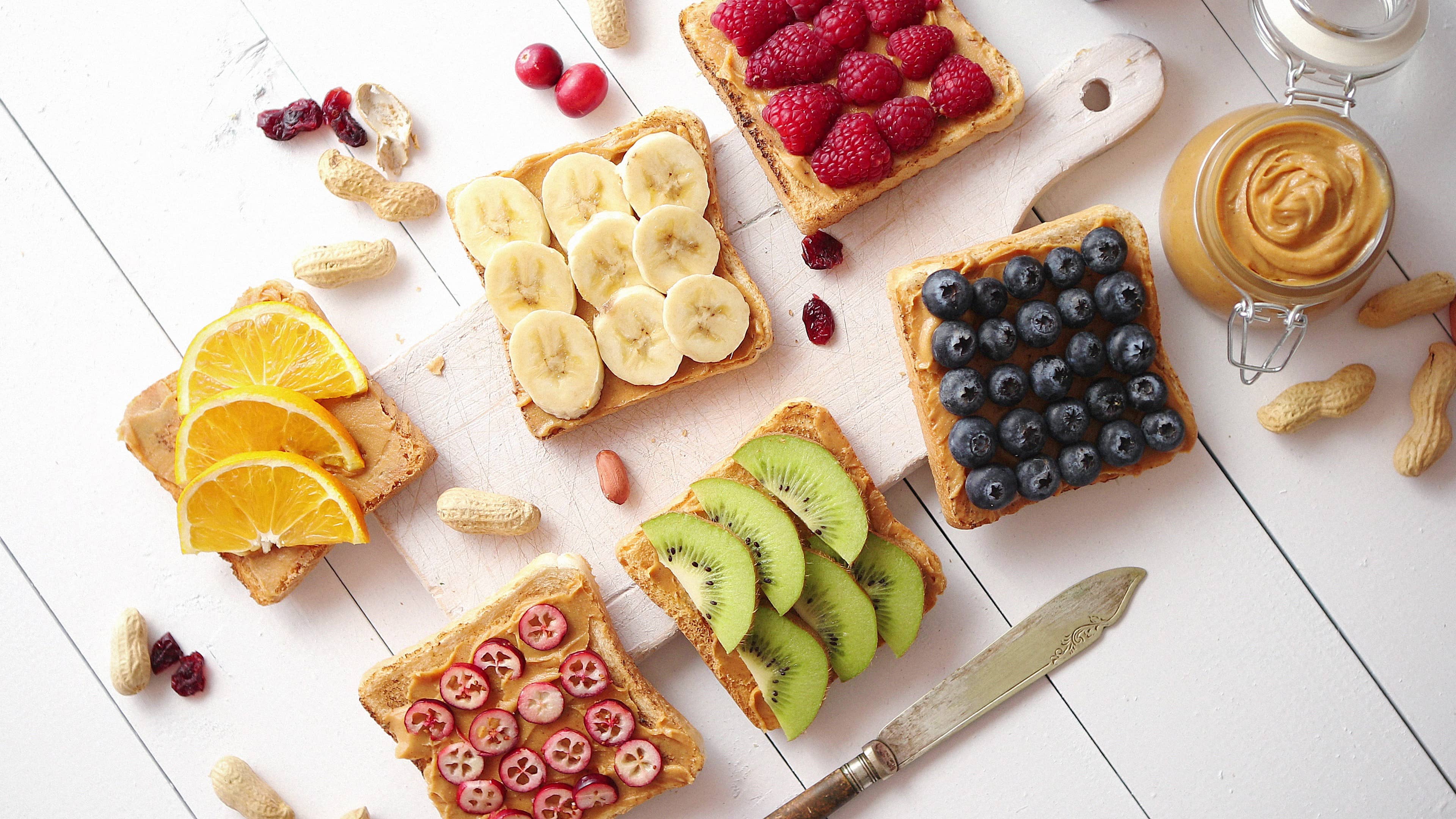 Assortment of healthy fresh breakfast toasts with peanut butter and fruits