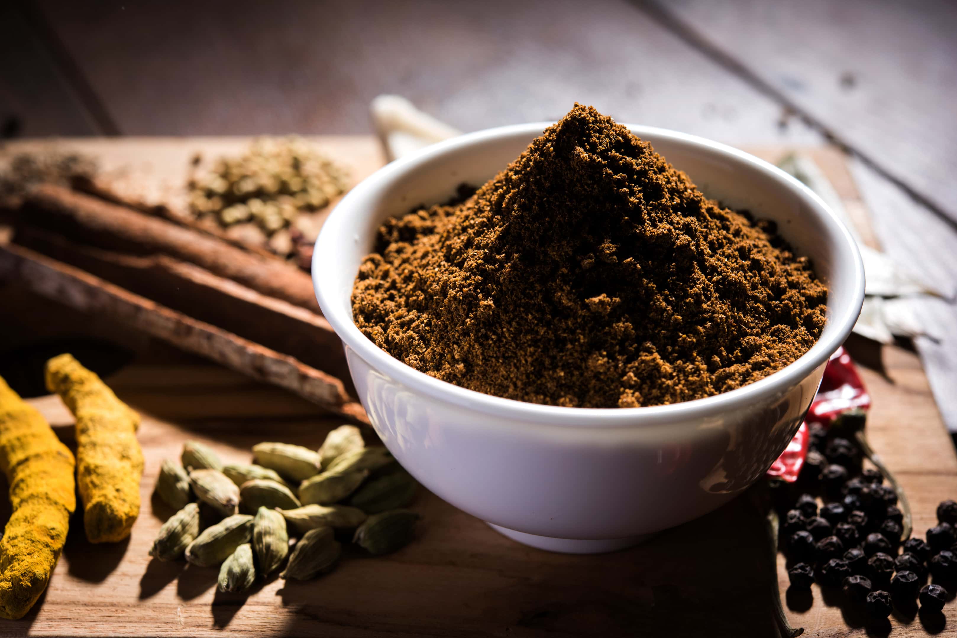 Kala jeera methi ajwain powder in a bowl surrounded with colourful spices