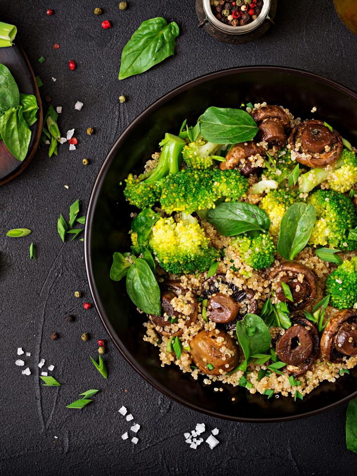 Healthy vegan salad of vegetables - broccoli, mushrooms, spinach and quinoa in a bowl