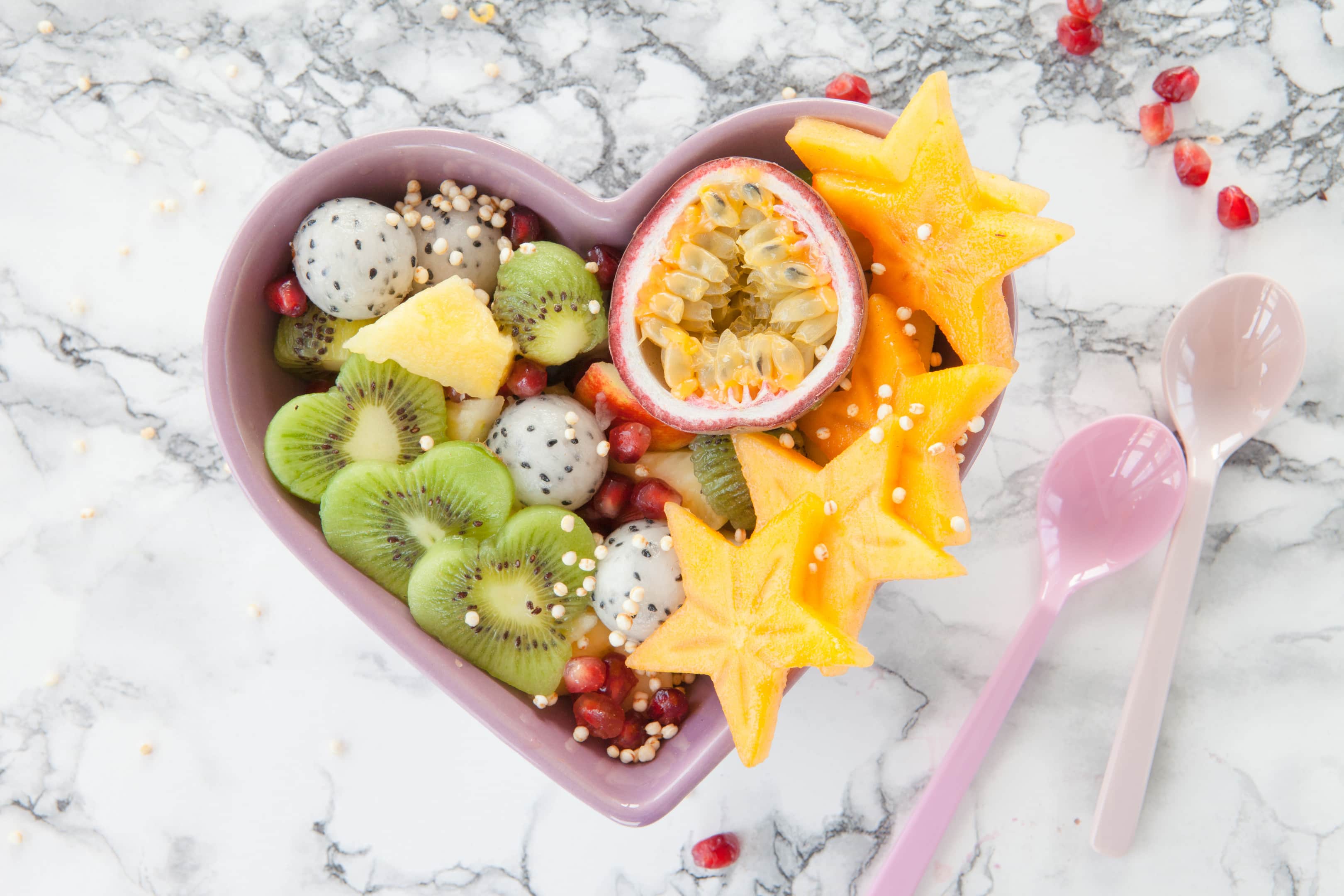 Fresh fruit salad made from exotic tropical fruits in a heart bowl