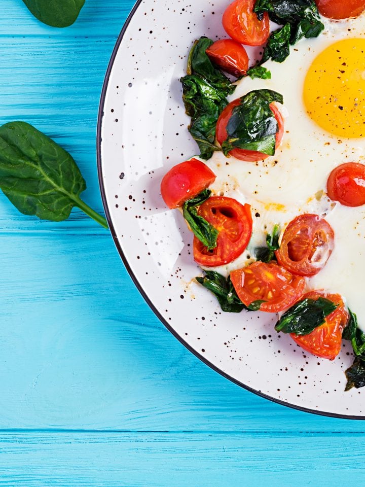 Fried egg, spinach, and tomatoes in a plate