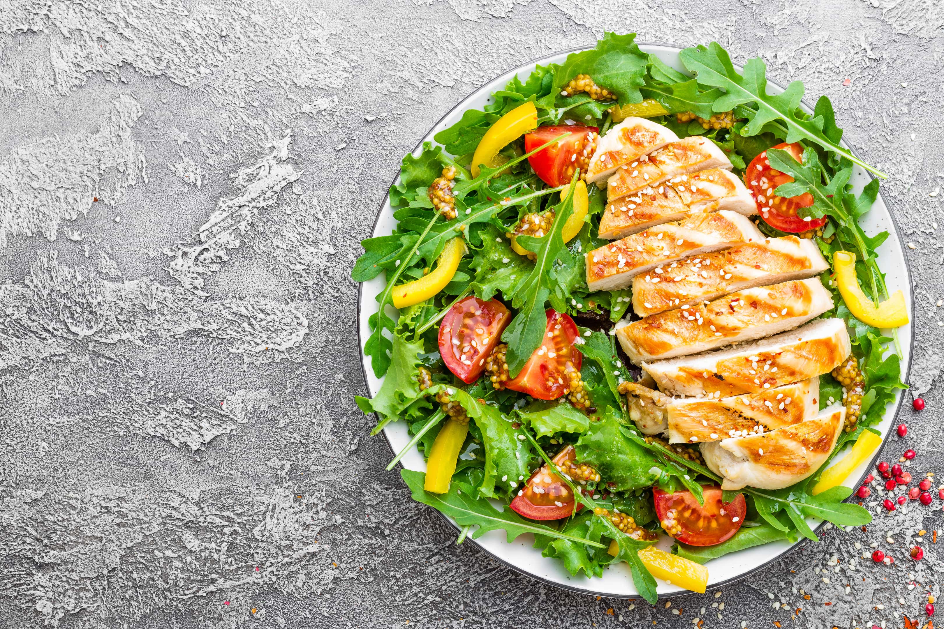 Salad with fresh tomato, sweet pepper, arugula and grilled chicken breast
