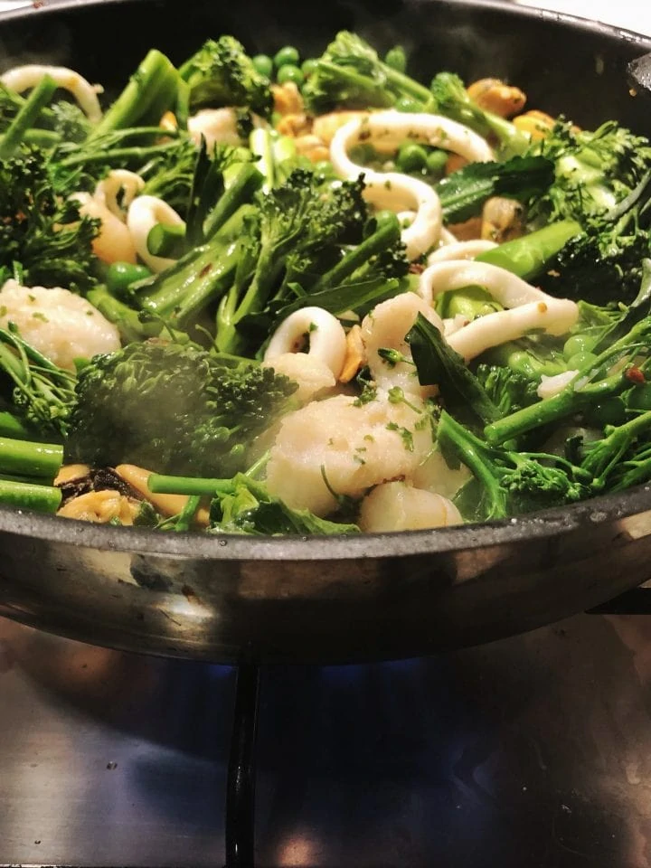 Cooking seafood and green vegetables Broccolini