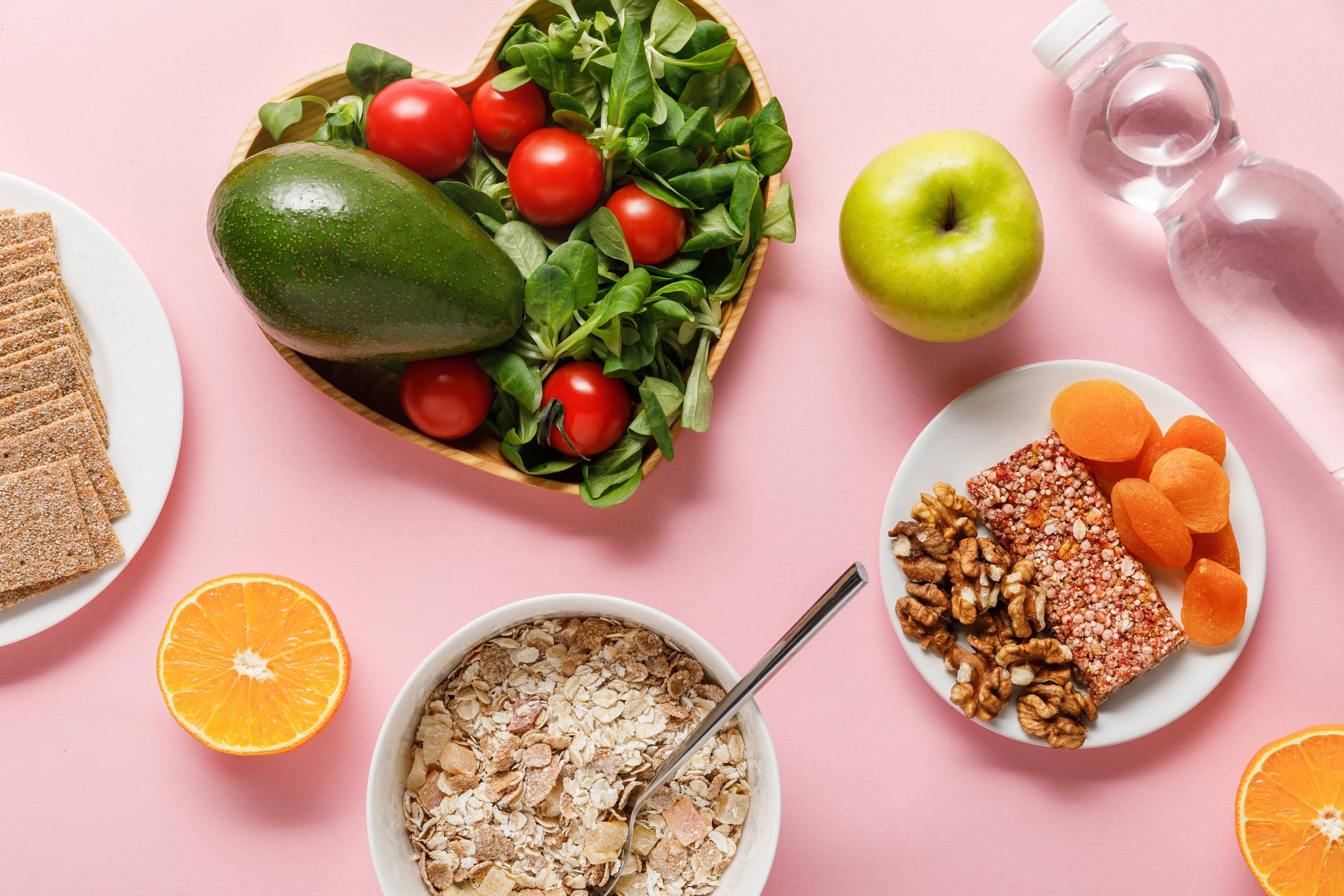 Top view of fresh diet food and water on pink background