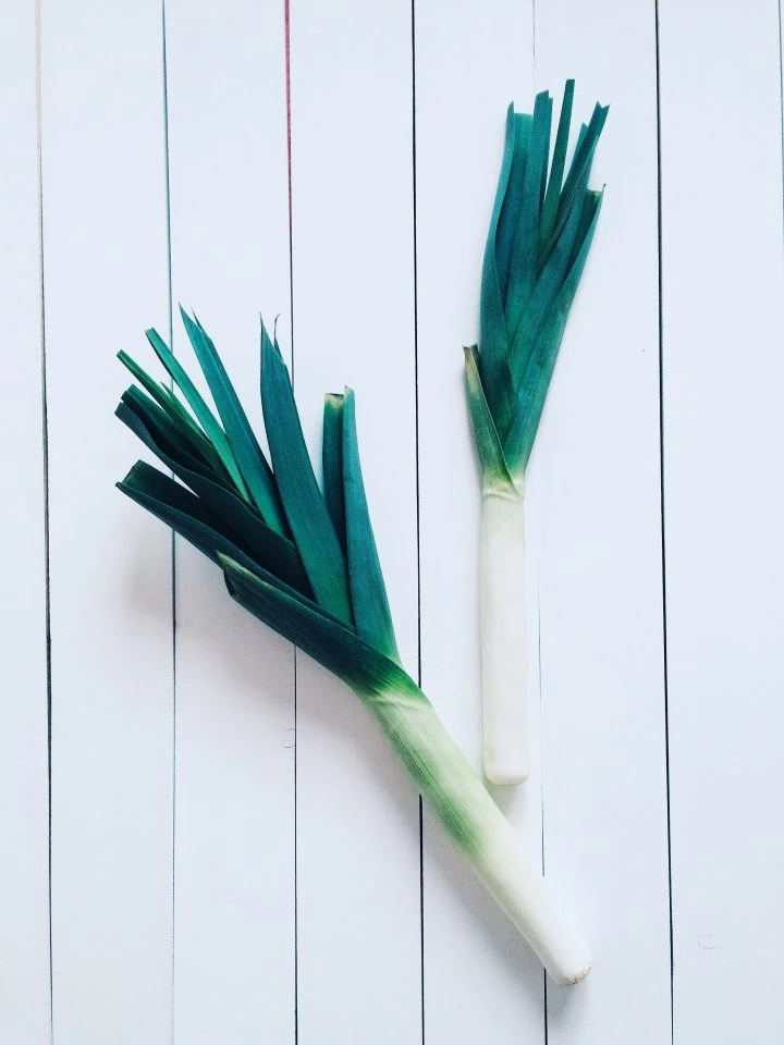 Fresh leeks on a white table