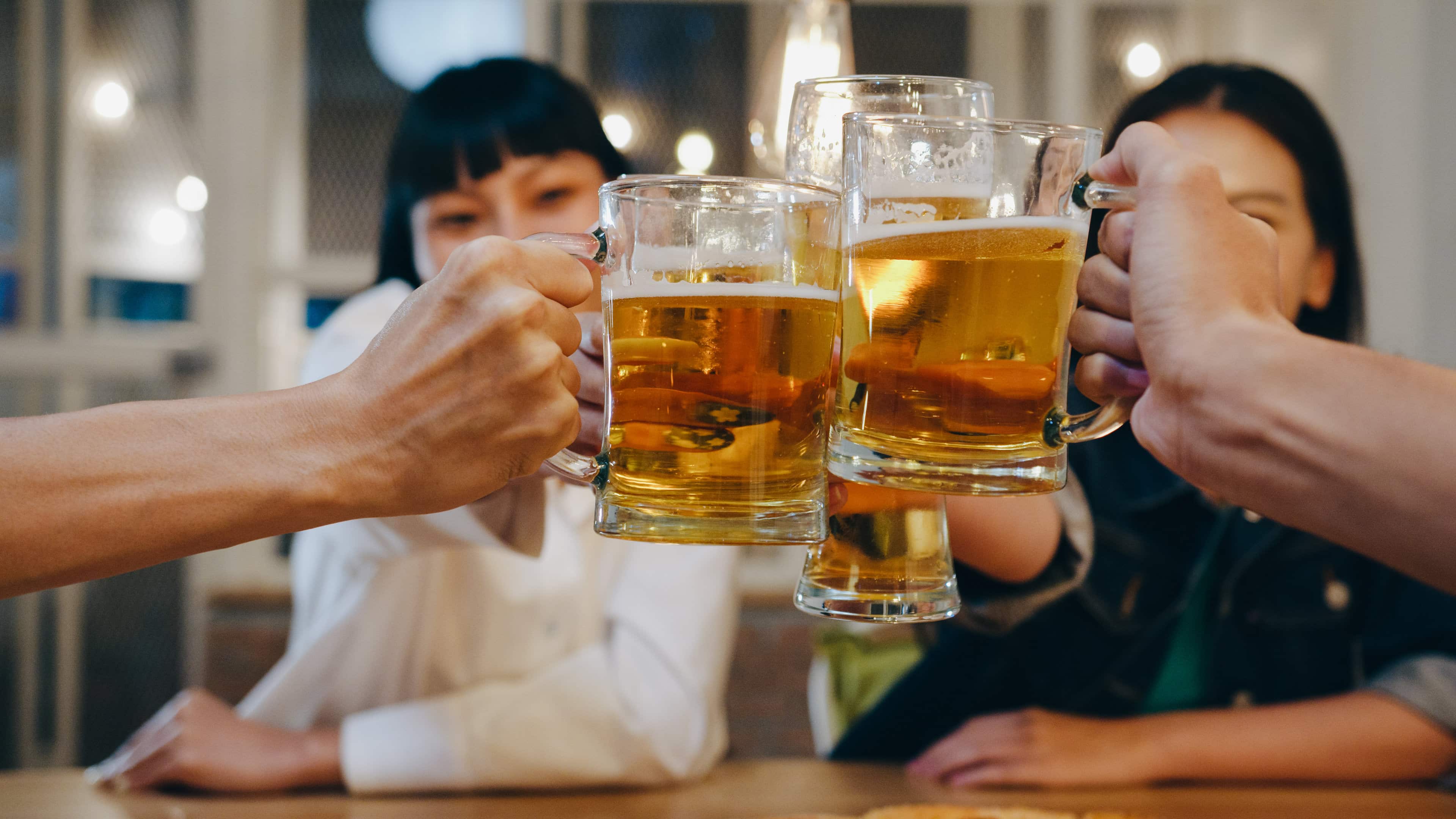 Group of young adults drinking craft beer. Does alcohol help digestion? It depends.