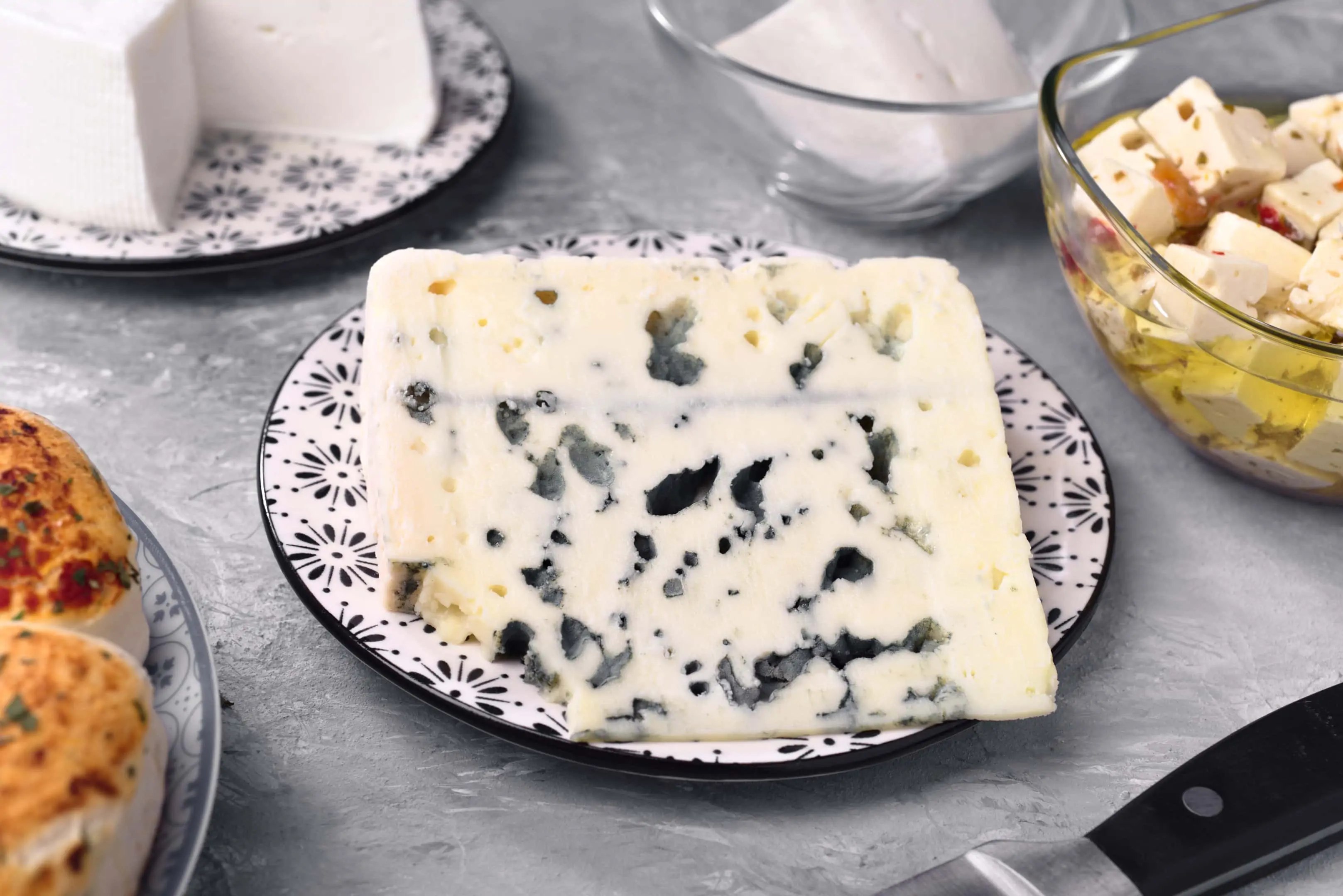 A piece of black owl cheese and other types of cheeses