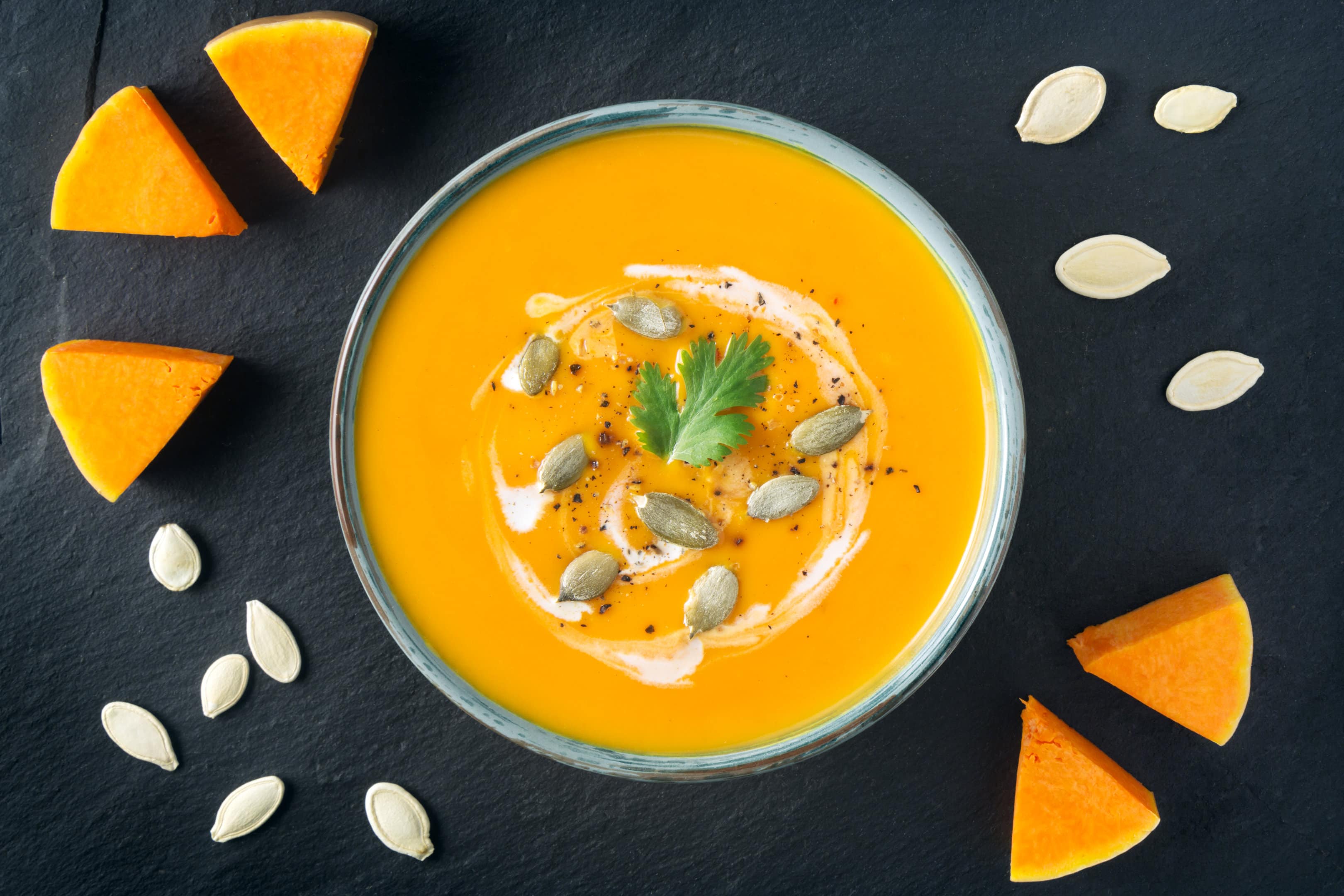 Creamy butternut squash soup recipe with butternut squash slices and seeds