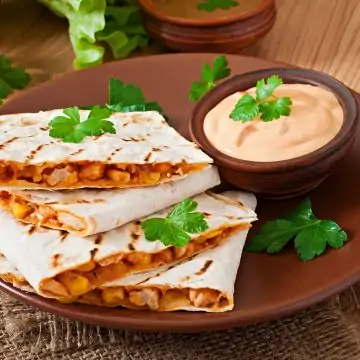 Mexican cheese quesadilla sliced with vegetable sauce