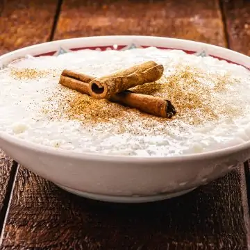 Sweet rice pudding with cooked rice and cinnamon stick
