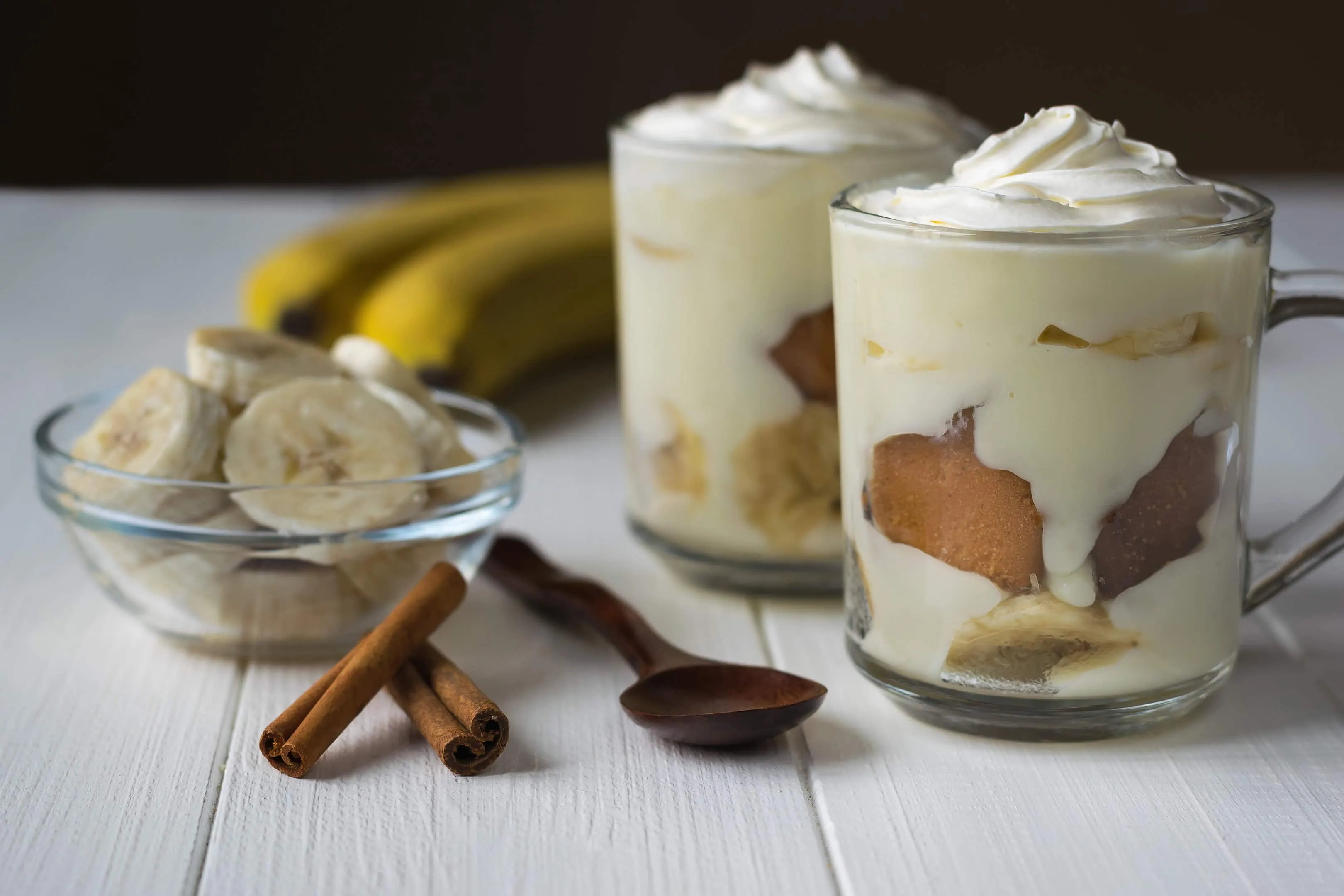 Two glasses of banana pudding no bake with banana slices and cinnamon