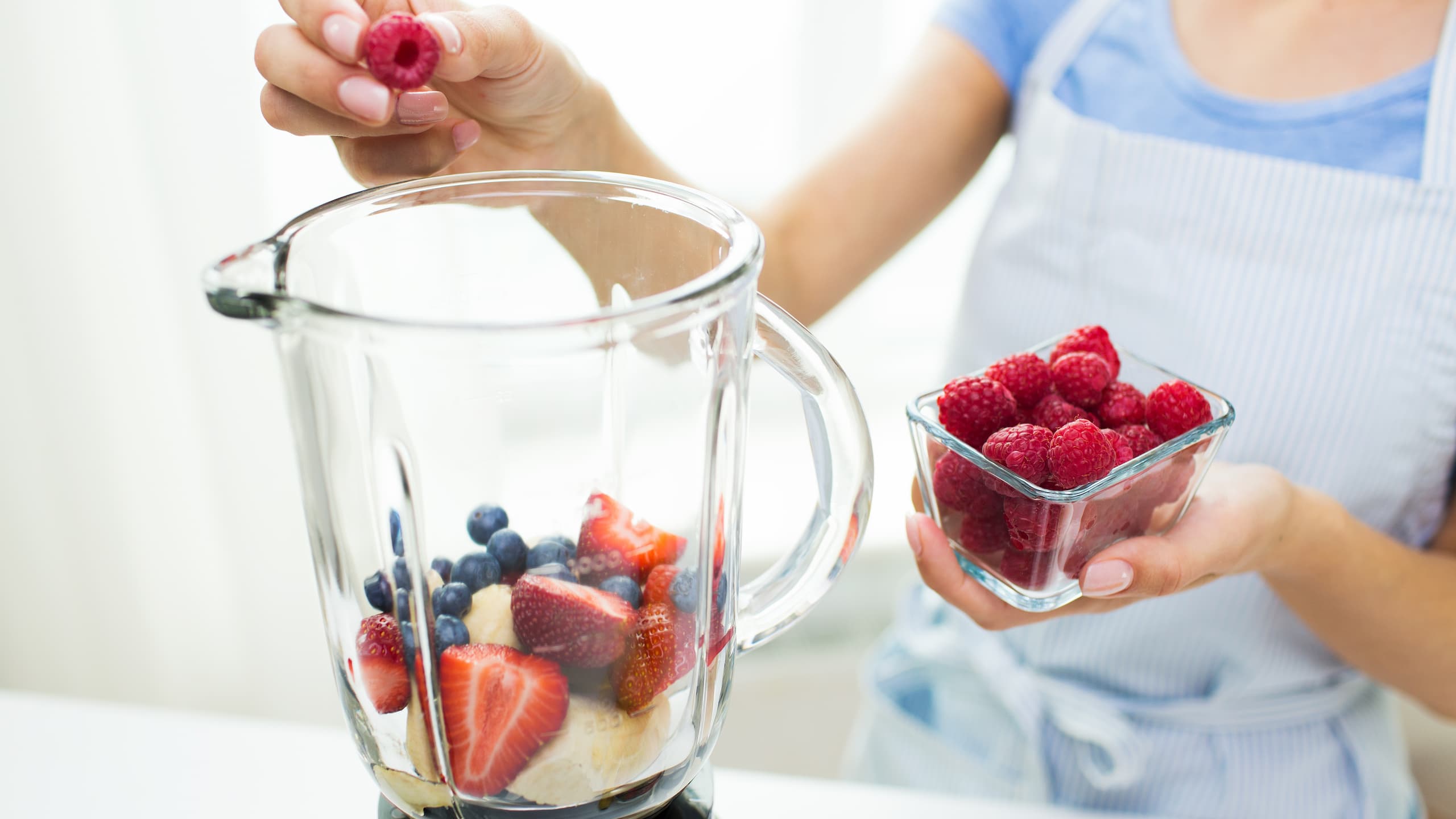 A woman is making Bahama Mama tropical fruit smoothie