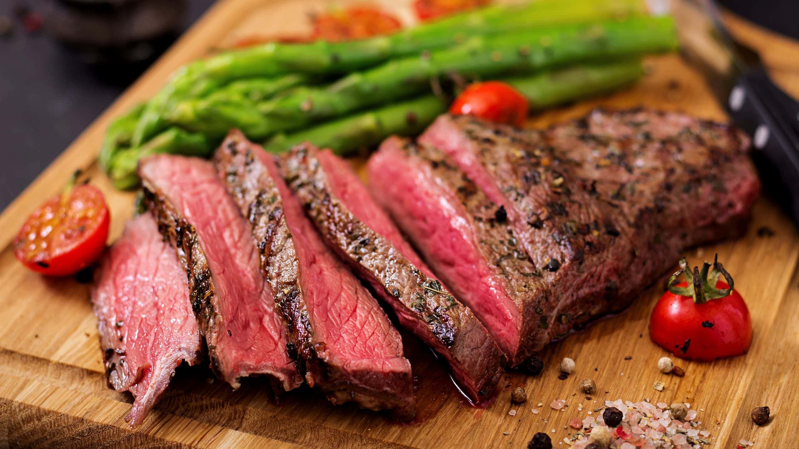 Juicy Pioneer Woman London Broil with spices, garnish, and asparagus